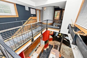 Un interior de varios niveles con una escalera, una zona de cocina y un baño.