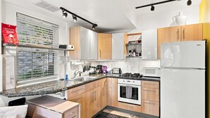 A modern kitchen with a built-in oven, microwave, and a white refrigerator.