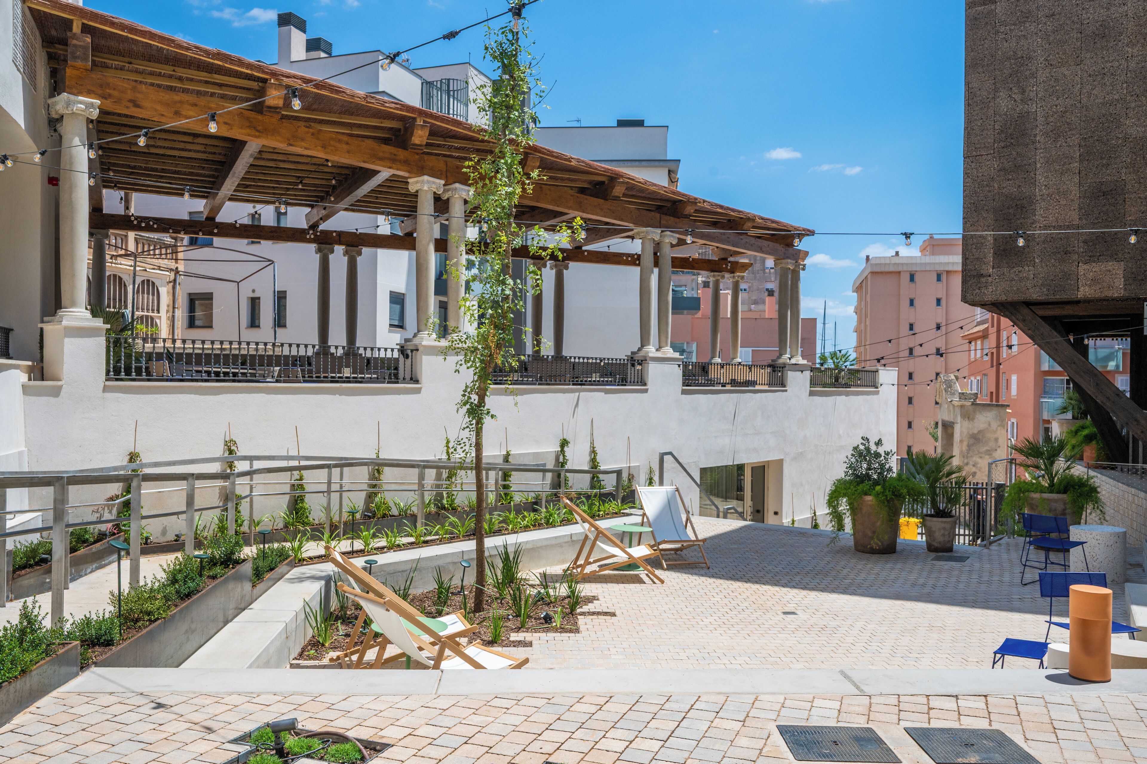An outdoor patio with seating, plants, and a pergola structure.