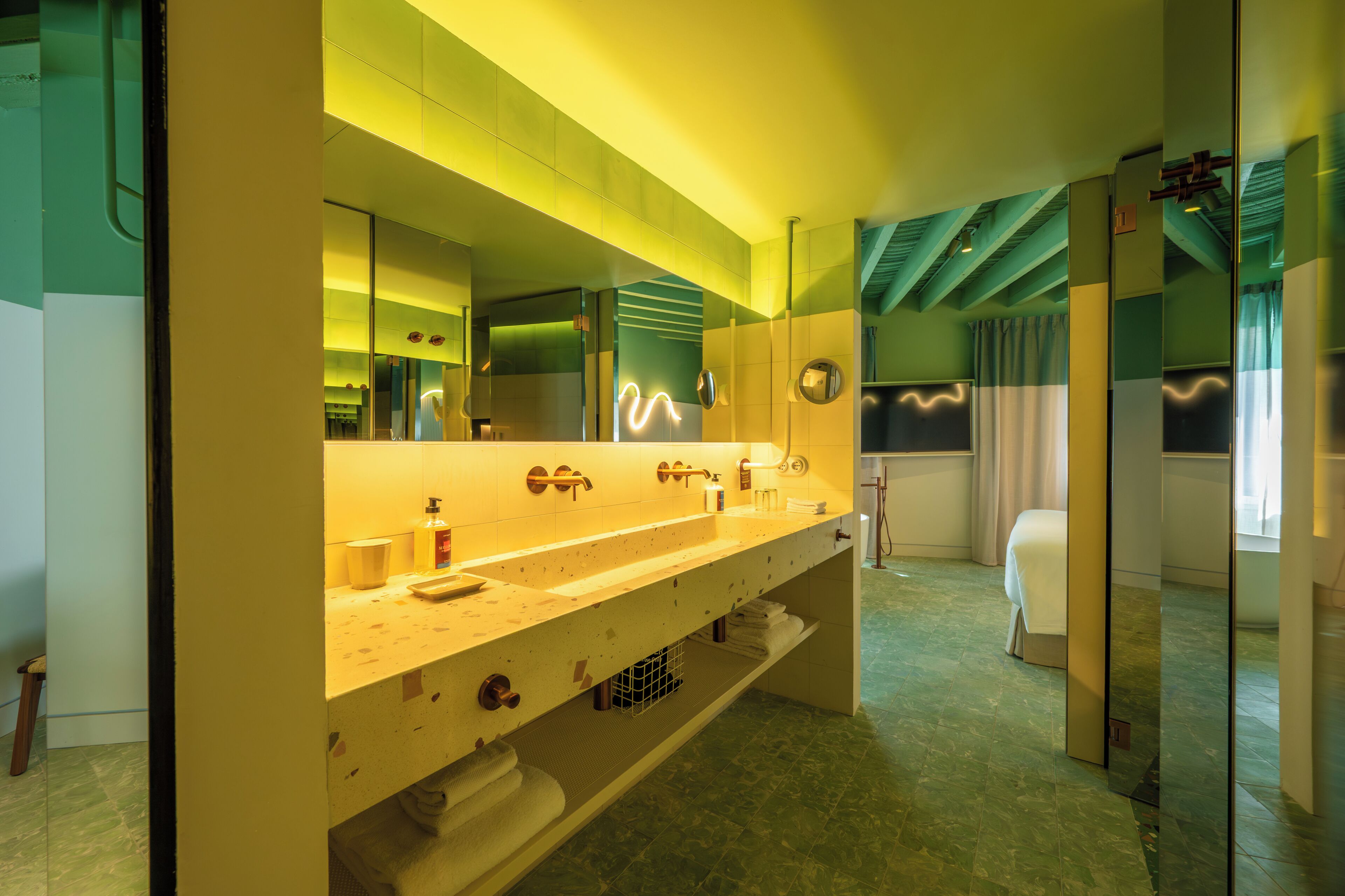 A modern bathroom with a large mirror, a sink, and a shower area.