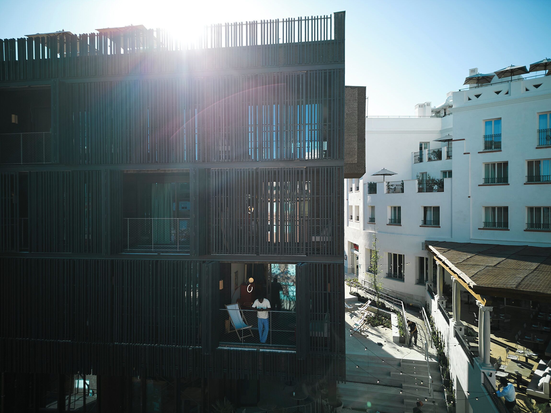 A multi-story building with balconies, a staircase, and a courtyard.