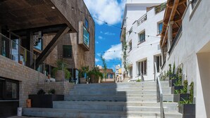 Un edificio urbano de varios niveles con escaleras, asientos exteriores y plantas en macetas.