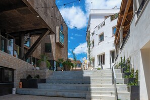A multi-level urban building with a staircase, outdoor seating, and potted plants. - Terreno Barrio Hotel - New Opening 2026 (Palma de Mallorca)