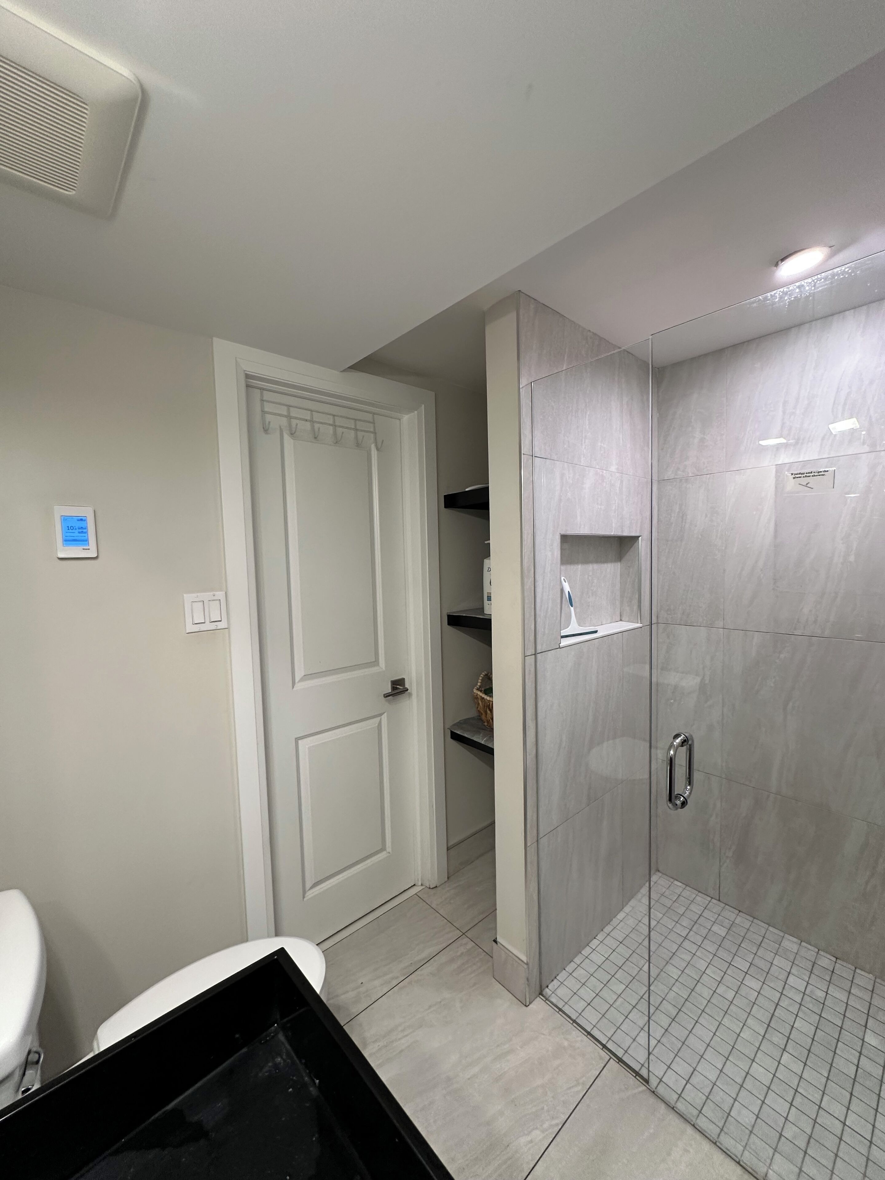 Un baño moderno con ducha a ras de suelo, inodoro y lavamanos.