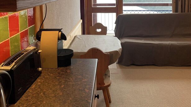 Un salon confortable avec un canapé et un coin repas comprenant une table et des chaises.