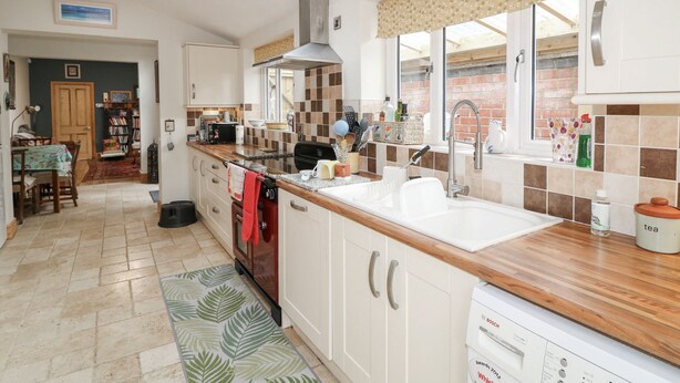 Una cocina moderna con una isla grande, horno empotrado y ventana con vistas al exterior.