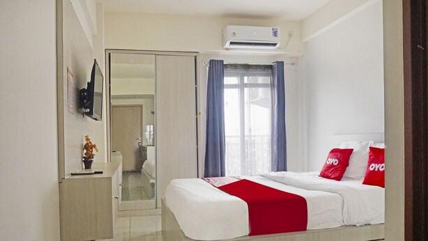 A hotel room with a bed, a bedside table, a mirror, and a wardrobe.