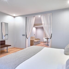 A bedroom with a bed, a desk, a chair, a sofa, and a table. - Hotel Turia Granada (Granada)