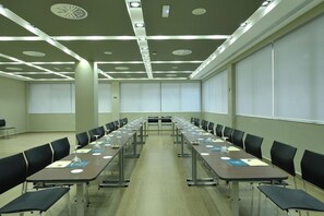 A conference room with long tables, chairs, and a projector screen. - Hotel Turia Granada (Granada)