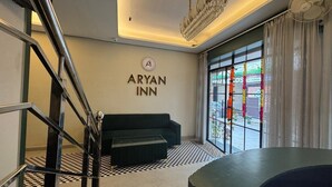 A modern hotel room with a staircase, a green sofa, a chandelier, and a large window with curtains. - Hotel Aryan Inn (Haridwar)
