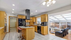 Una cocina moderna con armarios de madera, una isla central y un comedor con vistas.