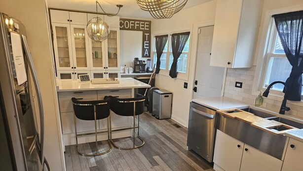 A modern kitchen with a central island, bar stools, a coffee station, and a dishwasher. - Family-Friendly Home with Style & Space (Chicago)