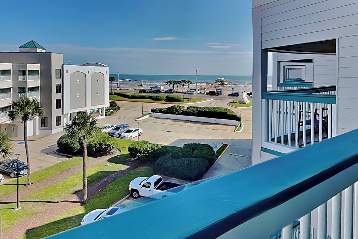 Un hotel moderno con vistas a la playa, zona de estacionamiento y piscina.