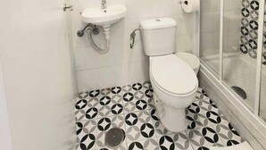 Kylpyhuone, jossa on wc, pesuallas ja suihku.