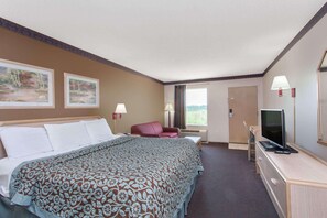 A hotel room with a large bed, a desk with a TV, a chair, and two windows. - Quality Inn & Suites Decatur - Priceville I-65 (Decatur)