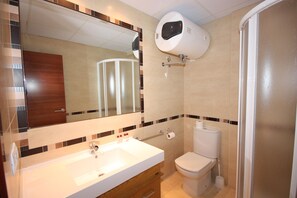 A bathroom with a sink, mirror, toilet, and a towel rack. - Campillo Apartamentos Rurales (La Iruela)