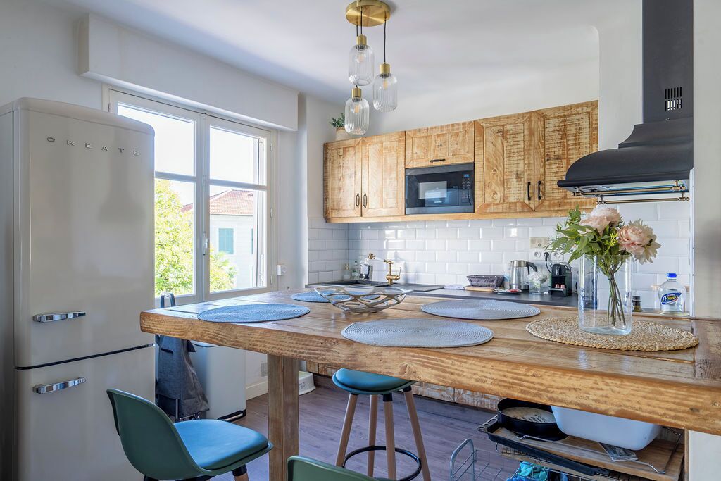 Una cocina moderna con armarios de madera, microondas integrado y una isla grande con taburetes.