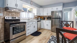 A modern kitchen with white cabinets, stainless steel appliances, and a wooden floor. - Comfortable 3 bedroom unit on a quiet street,close to downtown (Guelph)
