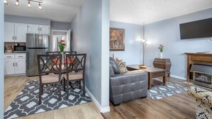 A modern kitchen with white cabinets and a stainless steel refrigerator. - Comfortable 3 bedroom unit on a quiet street,close to downtown (Guelph)