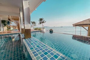 An infinity pool with a view of the sea, a wooden deck, and a modern architectural design. - Baan Sailboat Beach Kohlarn (Koh Larn)