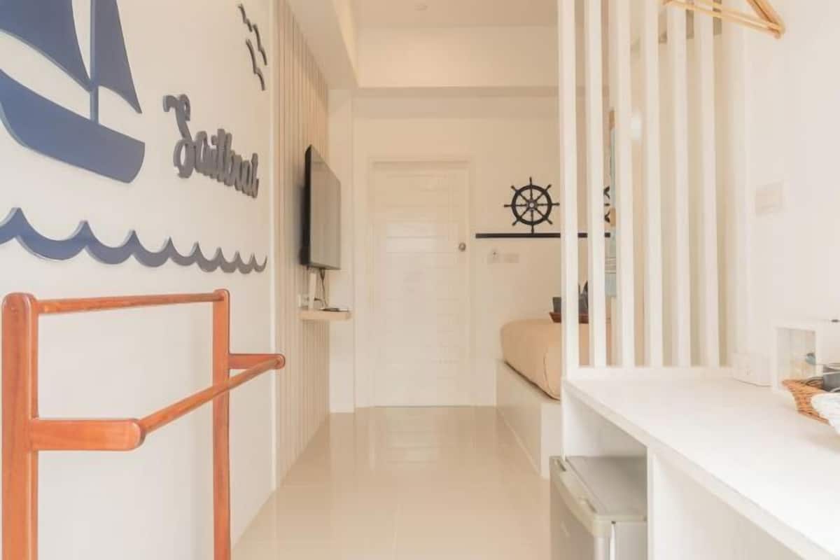 Un pasillo con televisión, una brújula en la pared y una puerta que da a otra habitación.