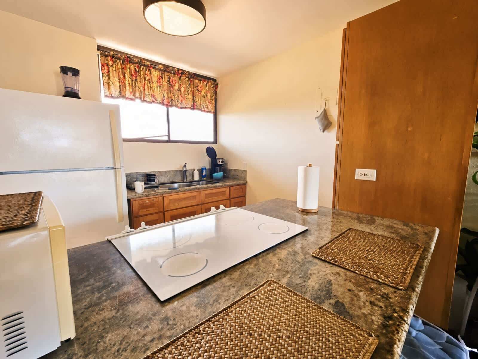 A compact kitchen with a refrigerator, stove, and sink.
