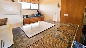 A compact kitchen with a refrigerator, stove, and sink.
