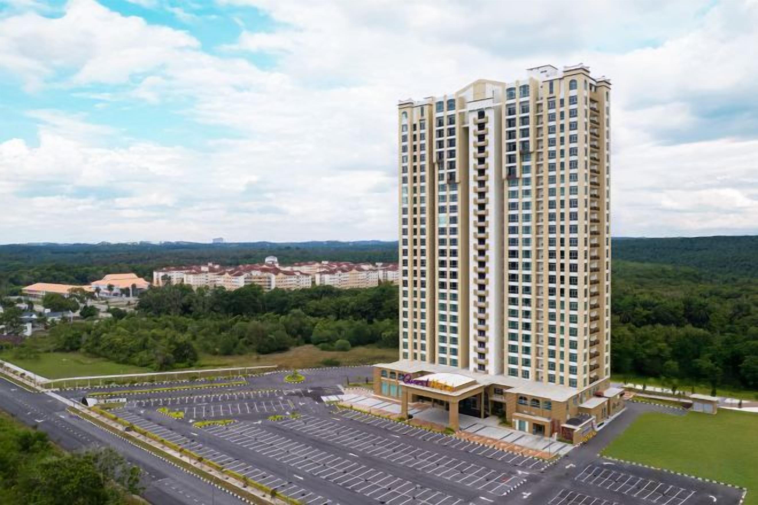 A high-rise building with a parking lot and a landscaped area in front.