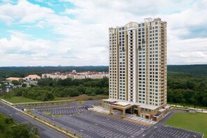 A high-rise building with a parking lot and a landscaped area in front. - Quest Hotel Midport Port Dickson (Si Rusa)