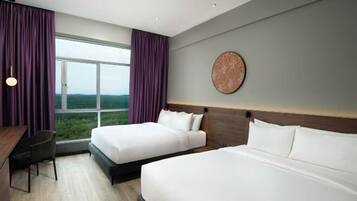 A hotel room with two beds, a desk, a chair, a large window with curtains, and a wall-mounted artwork.
