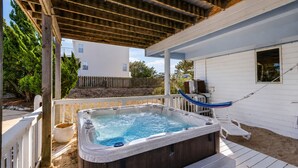 A hot tub on a wooden deck with a white fence, a hammock, and a small white building in the background. - Beach Retreat w/ Pool & Hot Tub (Virginia Beach)