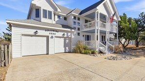 A two-story house with a garage labeled "Following Seas" and a balcony with an American flag. - Beach Retreat w/ Pool & Hot Tub (Virginia Beach)