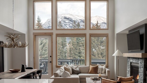 Una sala de estar moderna con chimenea, ventanas amplias y una zona de estar acogedora.