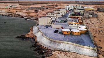 A coastal area with buildings, a road, and a sea wall.
