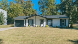 A single-story house with a garage, a front porch, and a well-maintained lawn. - Charming 3-bedroom house with AC, fitness room in fabulous Greenville (Greenville)