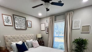 A bedroom with a large bed, a ceiling fan, and a window with curtains. - Charming 3-bedroom house with AC, fitness room in fabulous Greenville (Greenville)