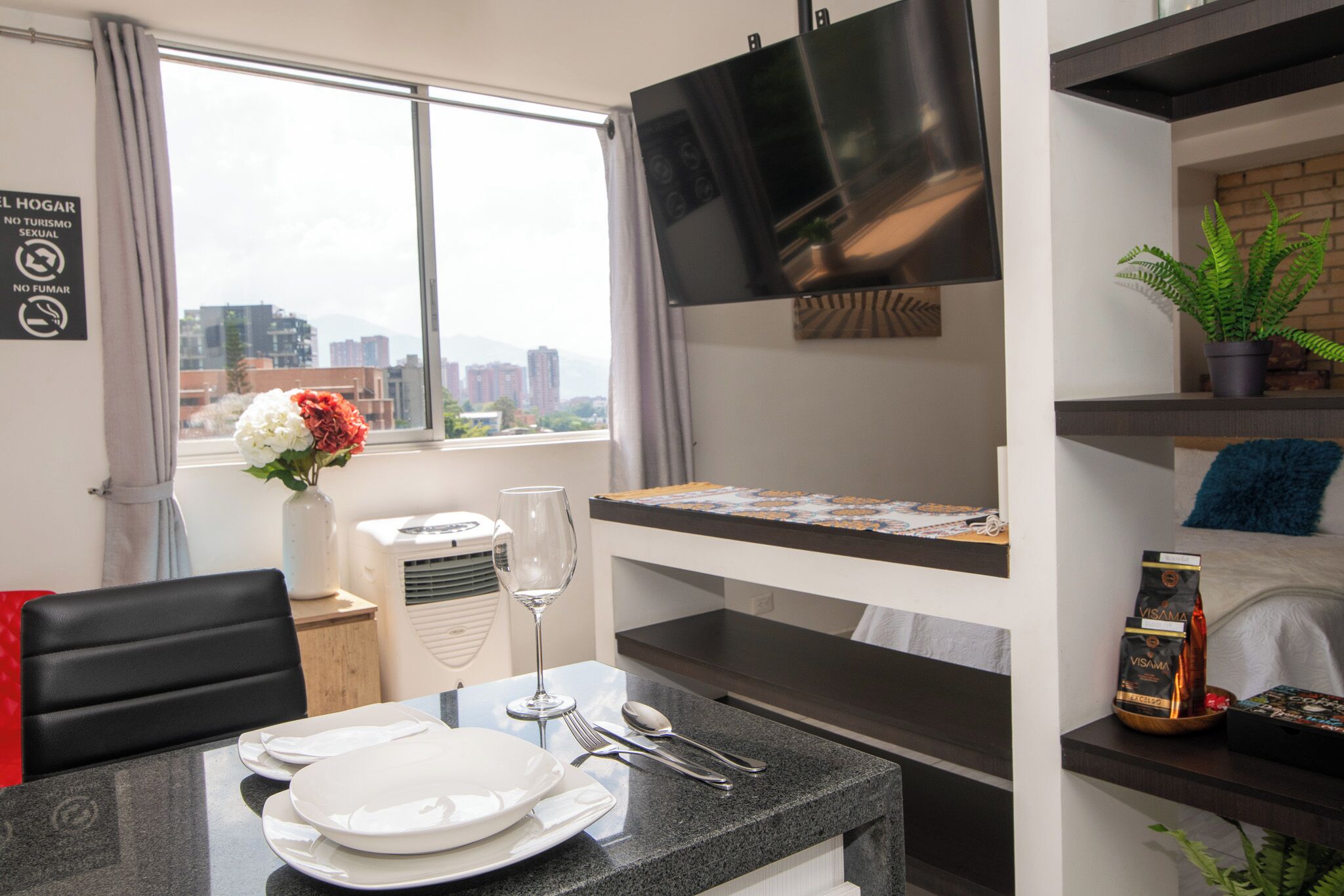 Eine moderne Küche mit Essbereich, einem Flachbildfernseher und Blick auf die Stadt.