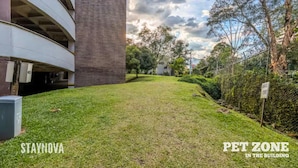 A building with a pet zone in the courtyard, surrounded by greenery and trees. - Staynova Comfortable Loft in El Poblado (Medellín)