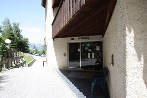 A building with a wooden balcony and a glass door entrance. - 300m from ski slopes, view mountain, balcony, tv, 21m², Pra Loup (Pra Loup)