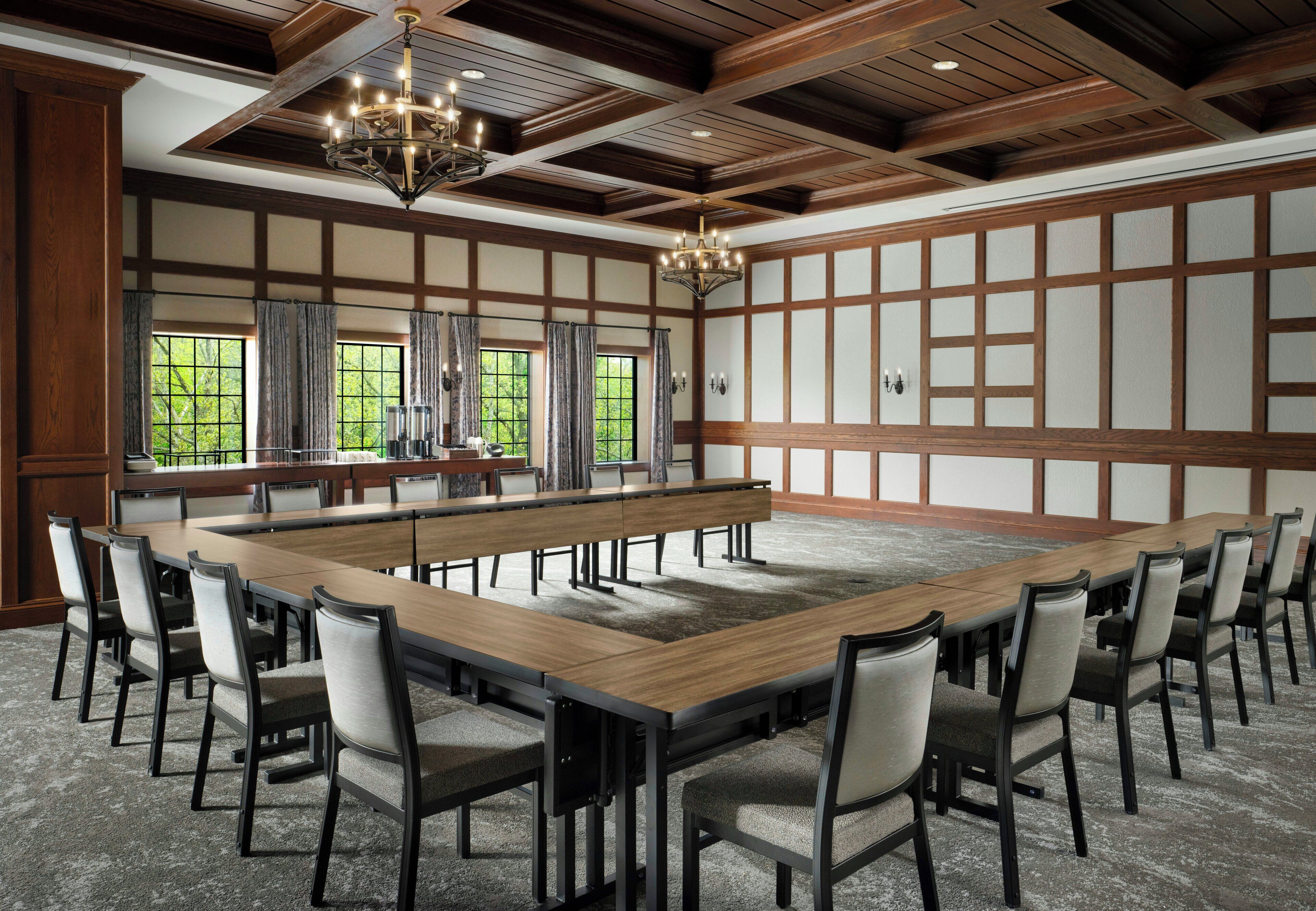 A conference room with a long table, chairs, and a chandelier.
