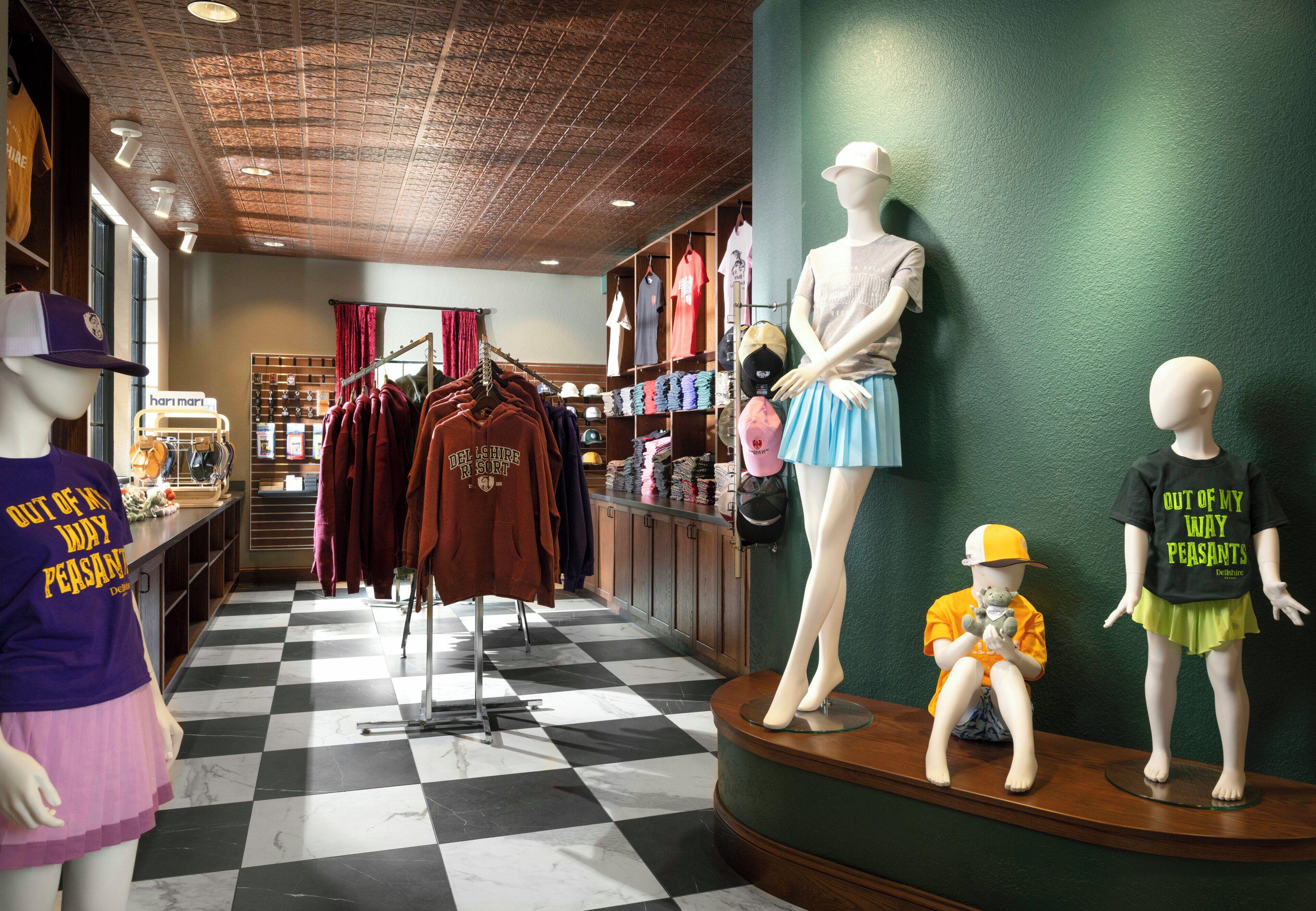 A retail store with mannequins displaying clothing and accessories.