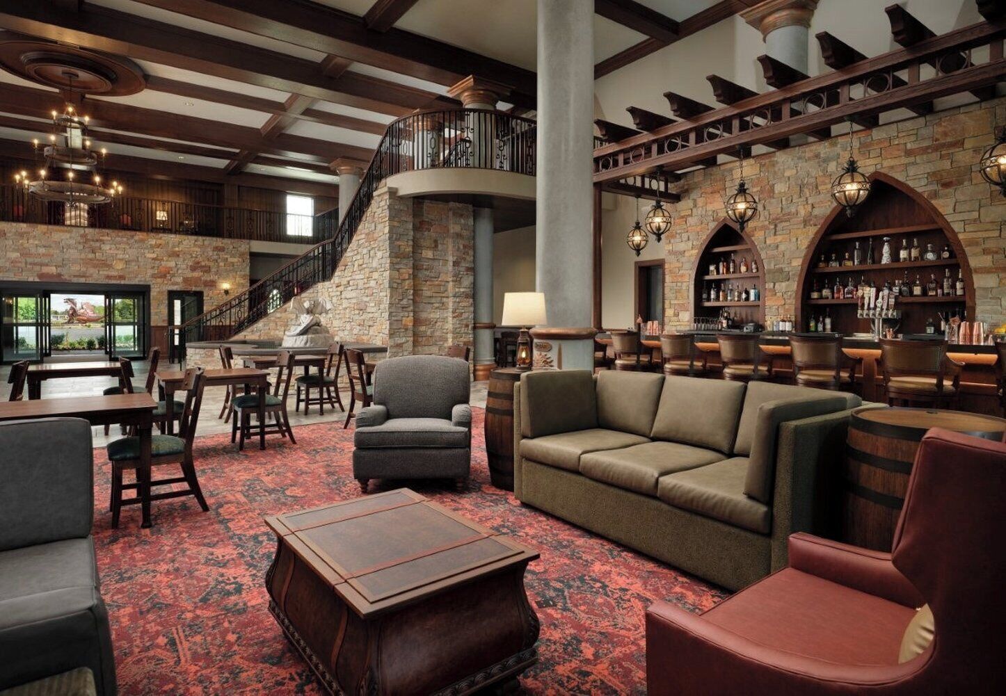 A spacious lounge area with a fireplace, comfortable seating, and a bar area with shelves of bottles.