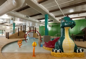 Area piscina con un grande dinosauro gonfiabile, uno scivolo e una scala.