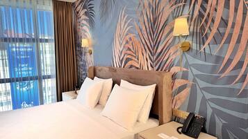 Deluxe kamer | Luxe beddengoed, een minibar, een kluis op de kamer, geluiddichte muren