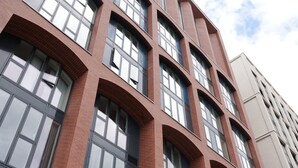 Un edificio de varios pisos con amplias ventanas y fachada de ladrillo.