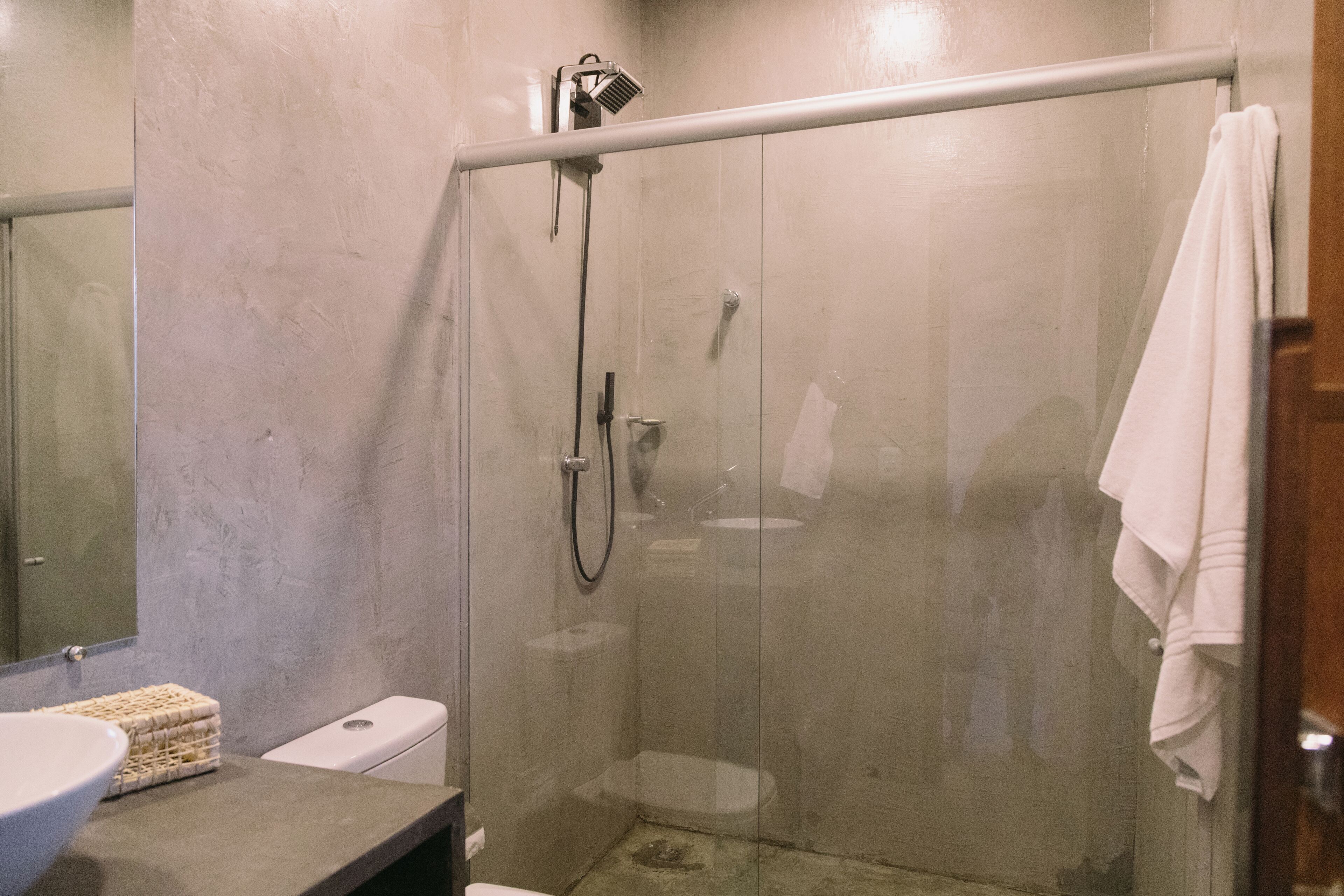 Un bagno moderno con doccia vetrata, lavabo e WC.