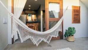 A hammock hanging over a doorway, a potted plant, and a wooden door. - La Casina Jericoacoara (Jijoca de Jericoacoara)