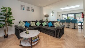 Ein modernes Wohnzimmer mit einem Ecksofa, einem runden Couchtisch und einem großen Fenster.
