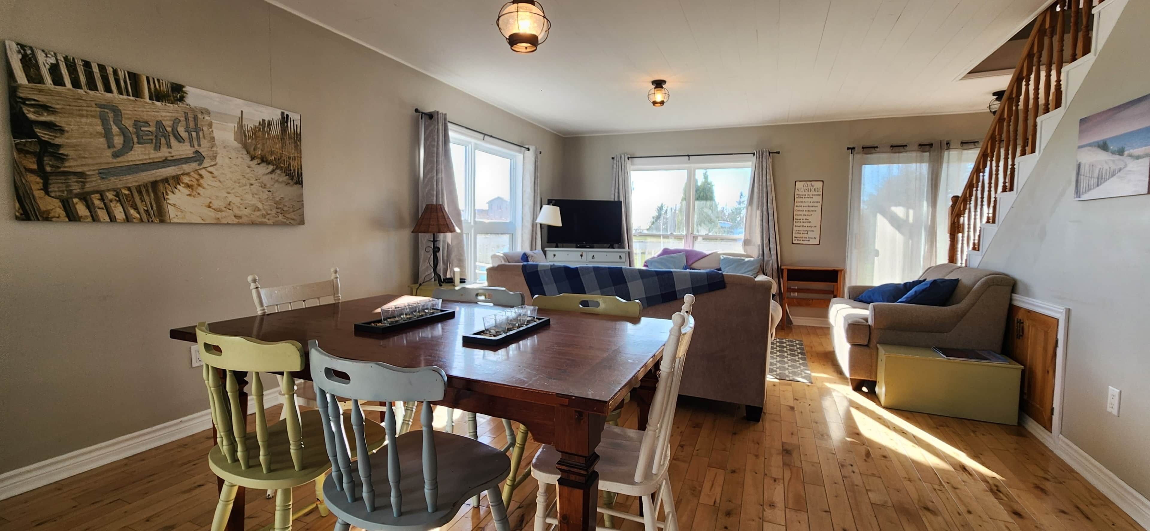 Una sala acogedora con una mesa de madera para comer, un sofá y un televisor.