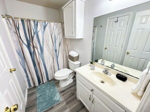 Een haardroger, handdoeken, zeep, toiletpapier